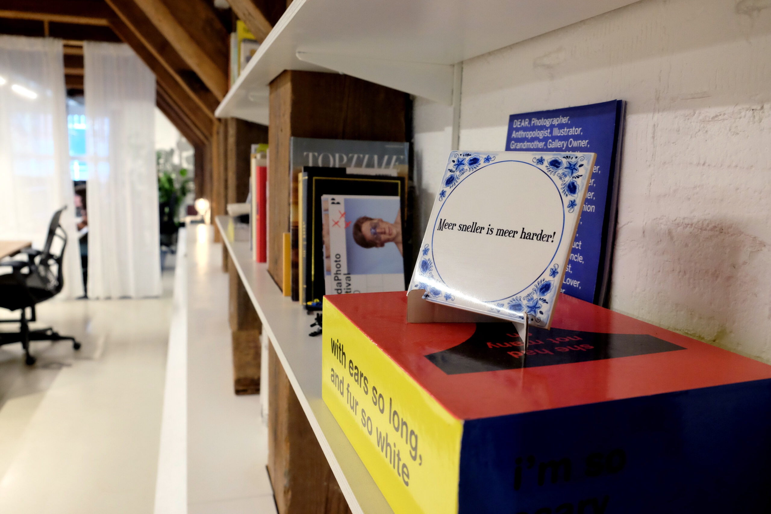A close-up picture of the office. On a tile, it reads in Dutch 'Meer sneller is meer harder'